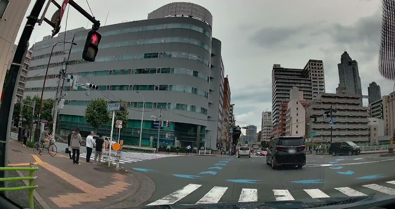 2026年の同じ交差点。交差点の中から先の車線へ、青い矢印状の表示が並ぶ